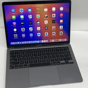 An Apple MacBook Air 2020 M1 (256GB, 16GB) in gray sits on a white surface with its screen open, displaying the iPadOS home screen full of app icons.